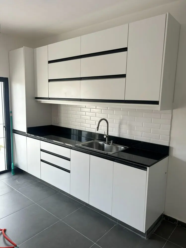 Cocina blanca con perfil gola negro y mesada de granito negro
